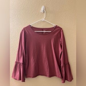 Burgundy shirt with ruffle sleeves.